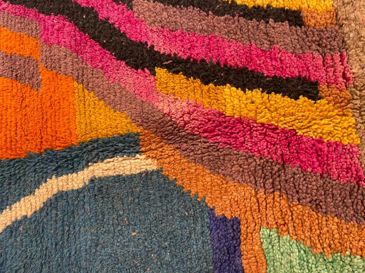 Detail close-up of a vintage Moroccan rug showcasing a textured surface with vibrant colors.