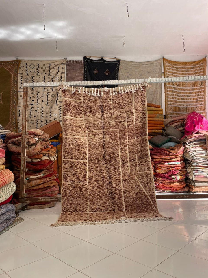 Lifestyle shot of a vintage Moroccan rug featuring brown and cream colors.