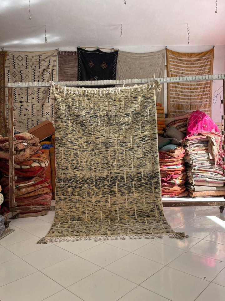 Lifestyle view of a vintage Moroccan rug featuring geometric patterns in beige and black.