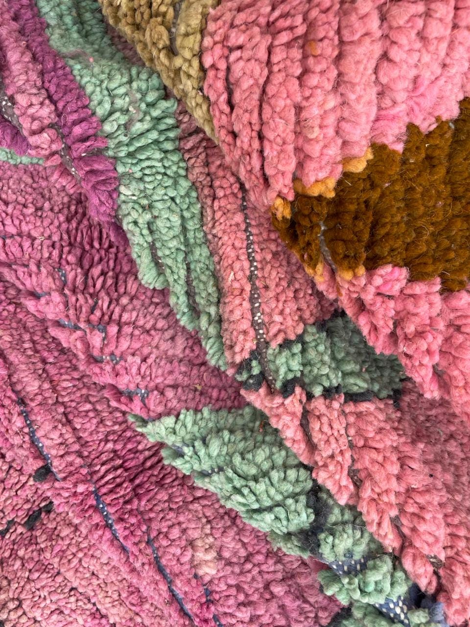 Detail shot of a vintage Moroccan rug with a textured pattern and colorful design.