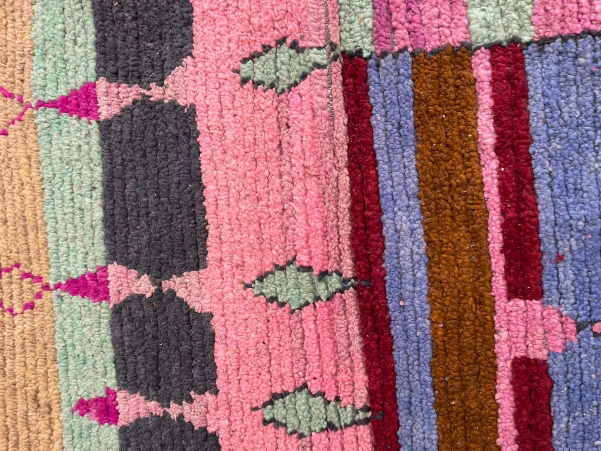 Detail shot of a colorful Moroccan rug with geometric patterns and varied textures.