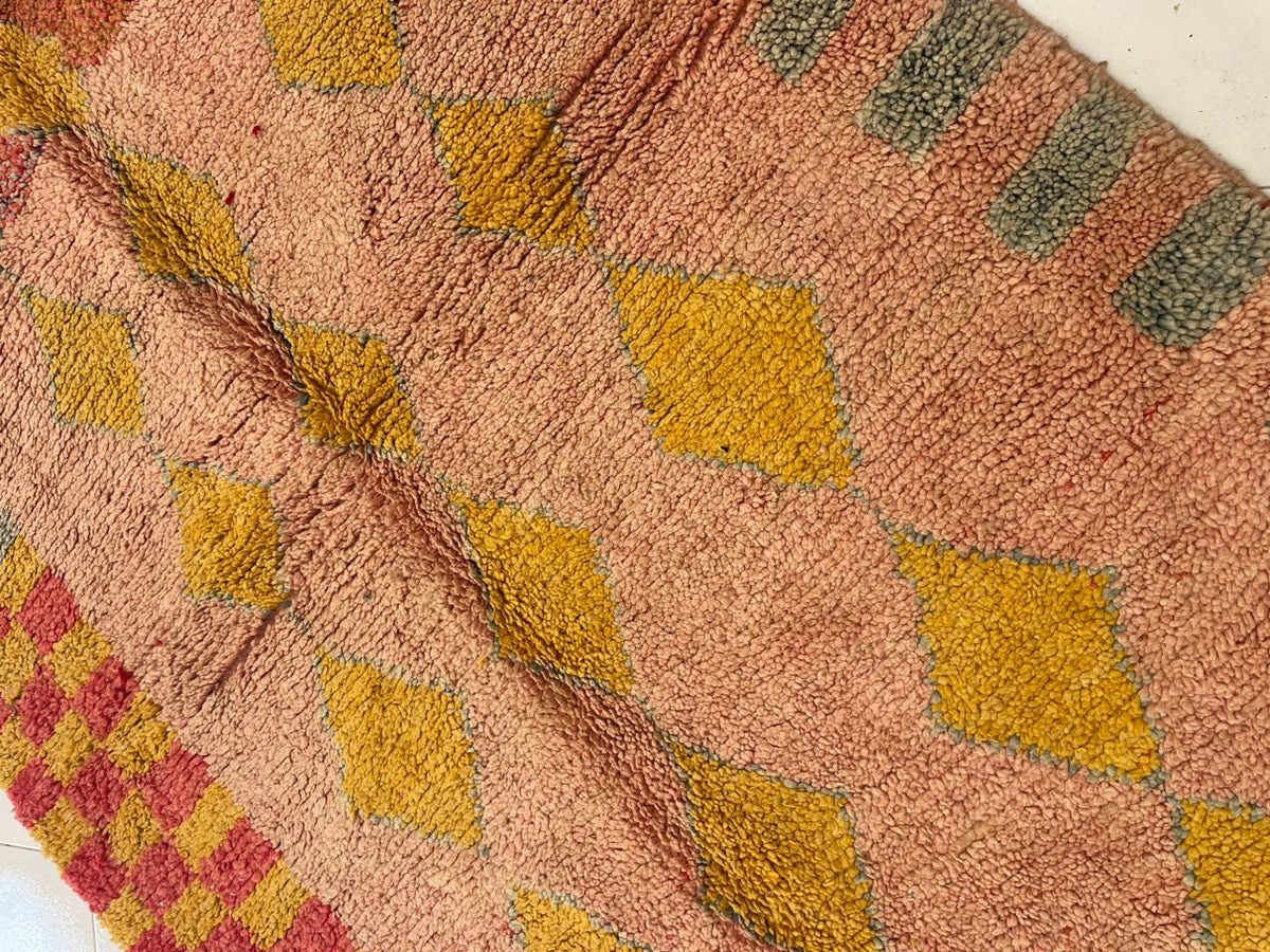 Detail view showcasing diamond motifs and a textured surface of the vintage Moroccan rug.