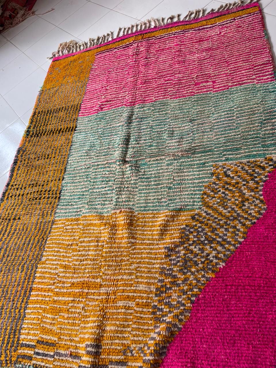Close-up detail of a pink vintage Moroccan rug featuring a patchwork design.