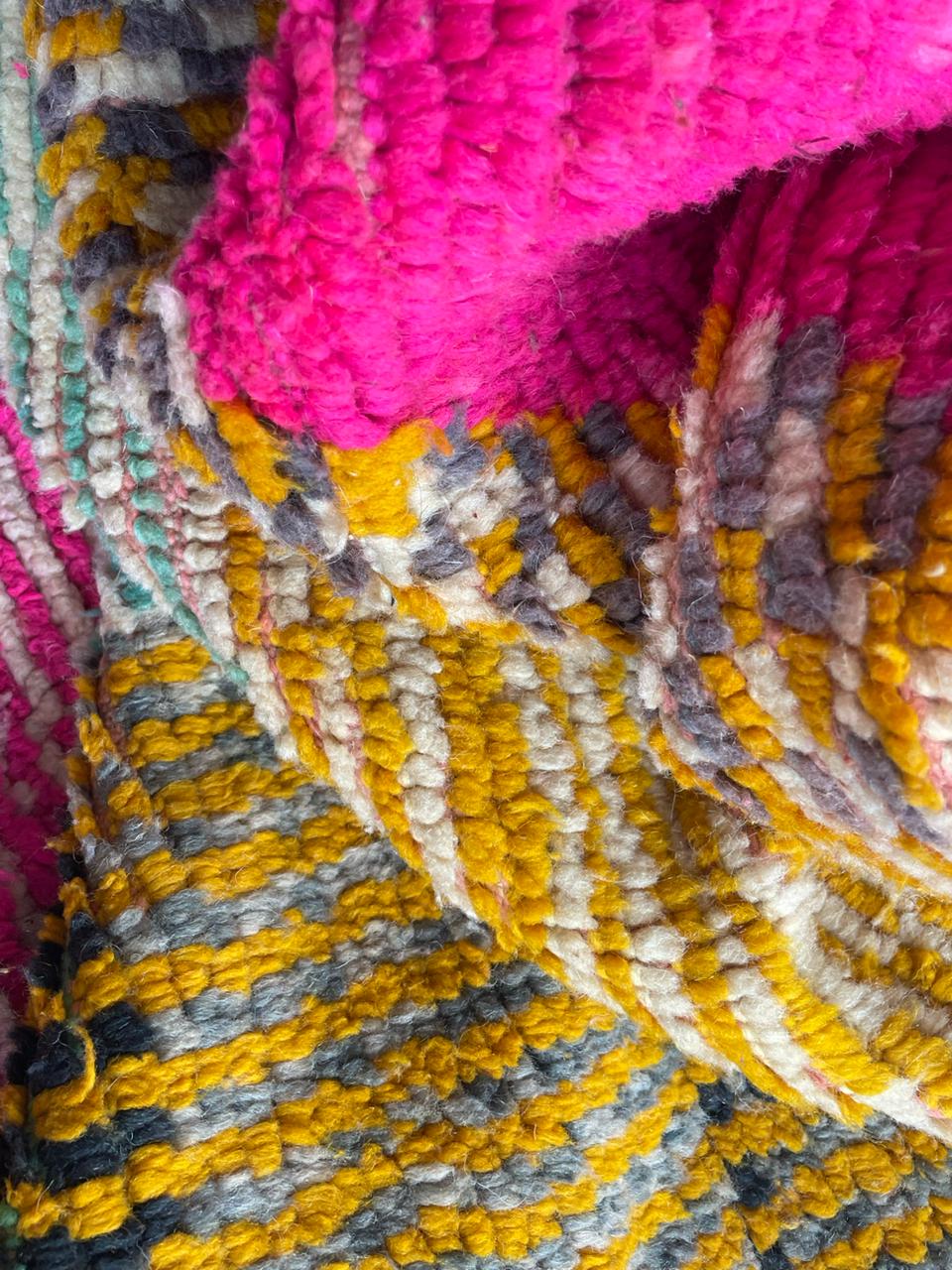 Close-up detail of a colorful Moroccan rug with a textured weave and vibrant colors.