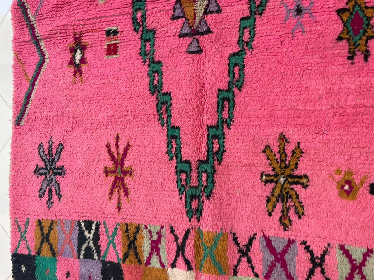 Detail close-up of a pink Moroccan rug showcasing wavy patterns and textured wool.