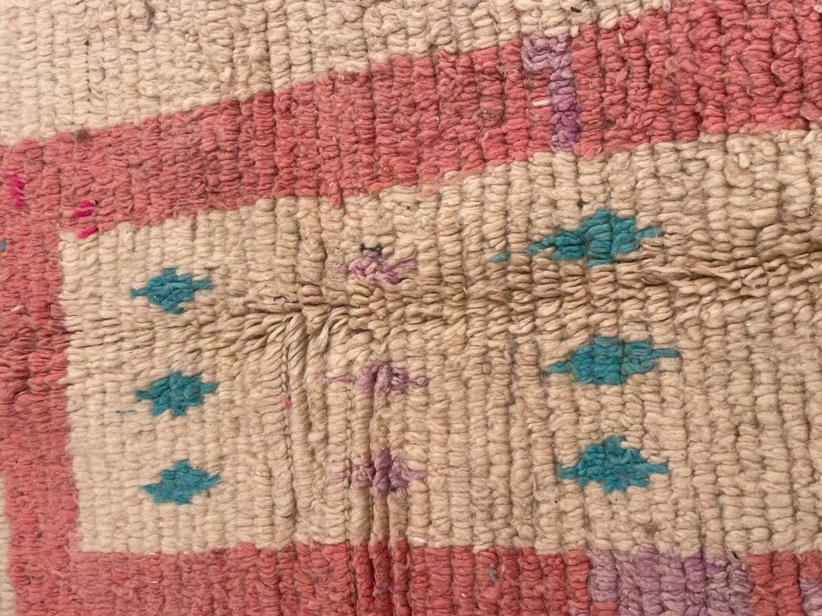 Close-up detail of a vintage Moroccan rug highlighting tribal motifs with a textured surface.