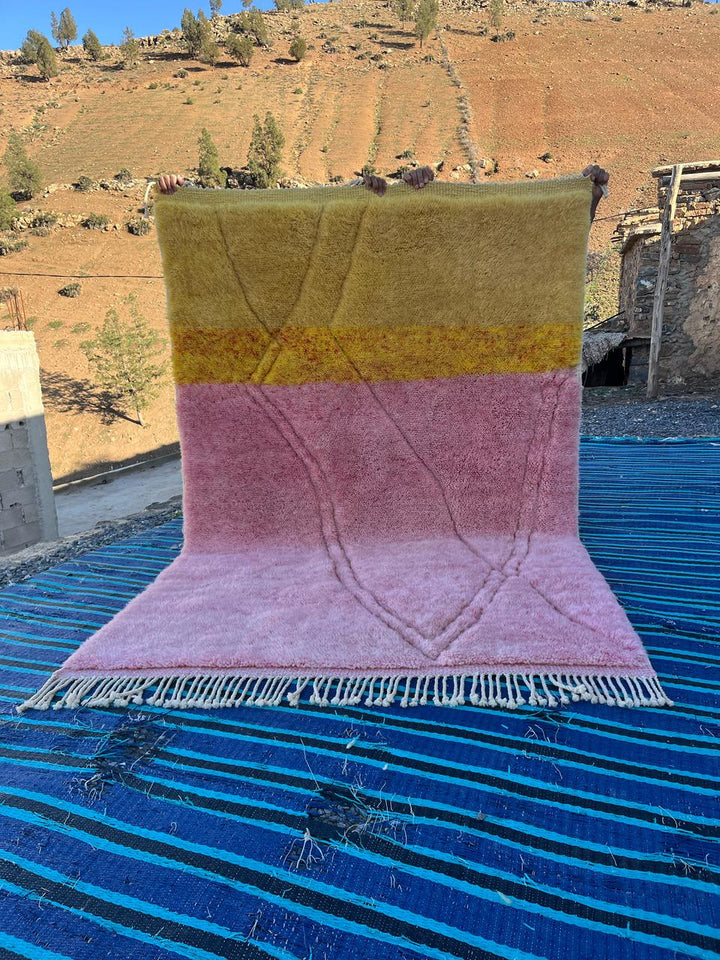 Front view of the pink and yellow Mrirt Moroccan rug showcasing fringe edges.