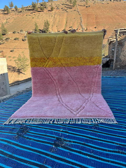 Front view of the pink and yellow Mrirt Moroccan rug showcasing fringe edges.
