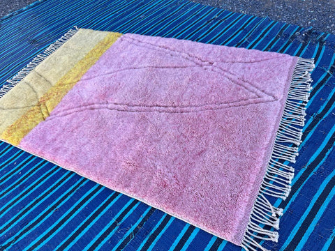 Front view of the pink and yellow Mrirt Moroccan rug highlighting its fringe edges.