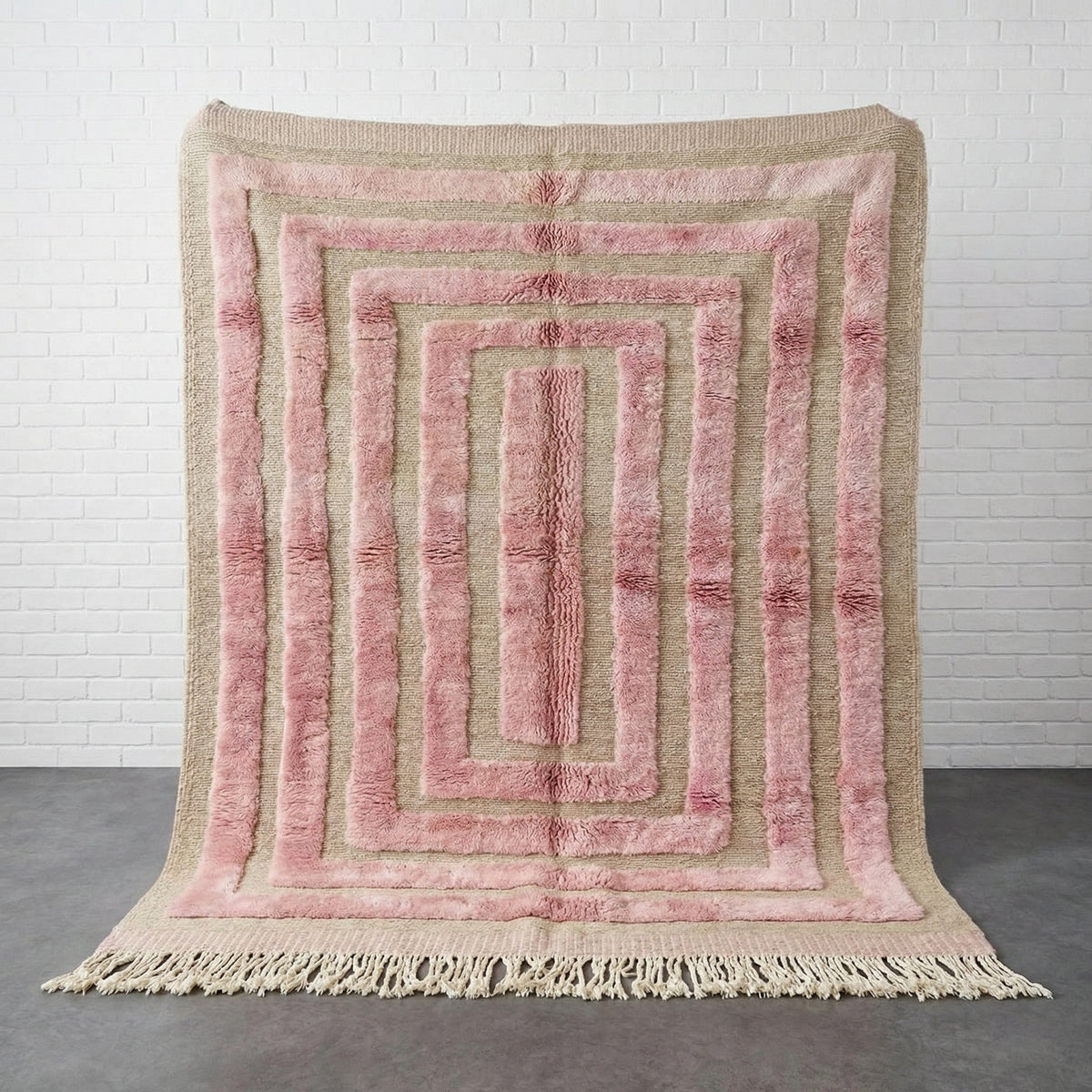 Front view of the pink grid rug featuring a tribal design on a white background.