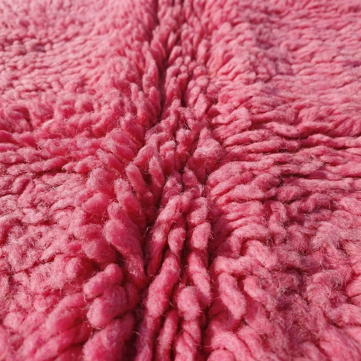 Close-up detail of the pink tribal rug showcasing its textured surface.
