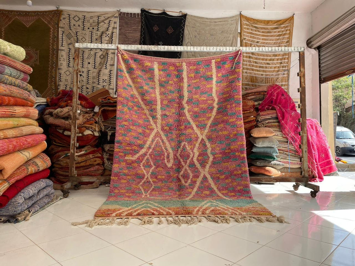 Lifestyle shot of the pink vintage Moroccan rug featuring decorative patterns and vibrant colors.