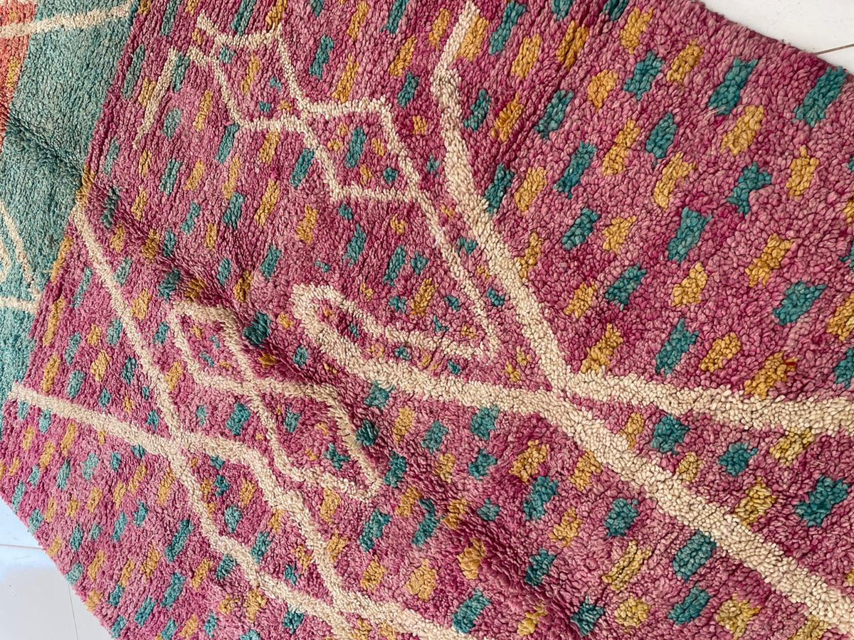 Detail close-up of the pink vintage Moroccan rug highlighting its textured surface and geometric patterns.