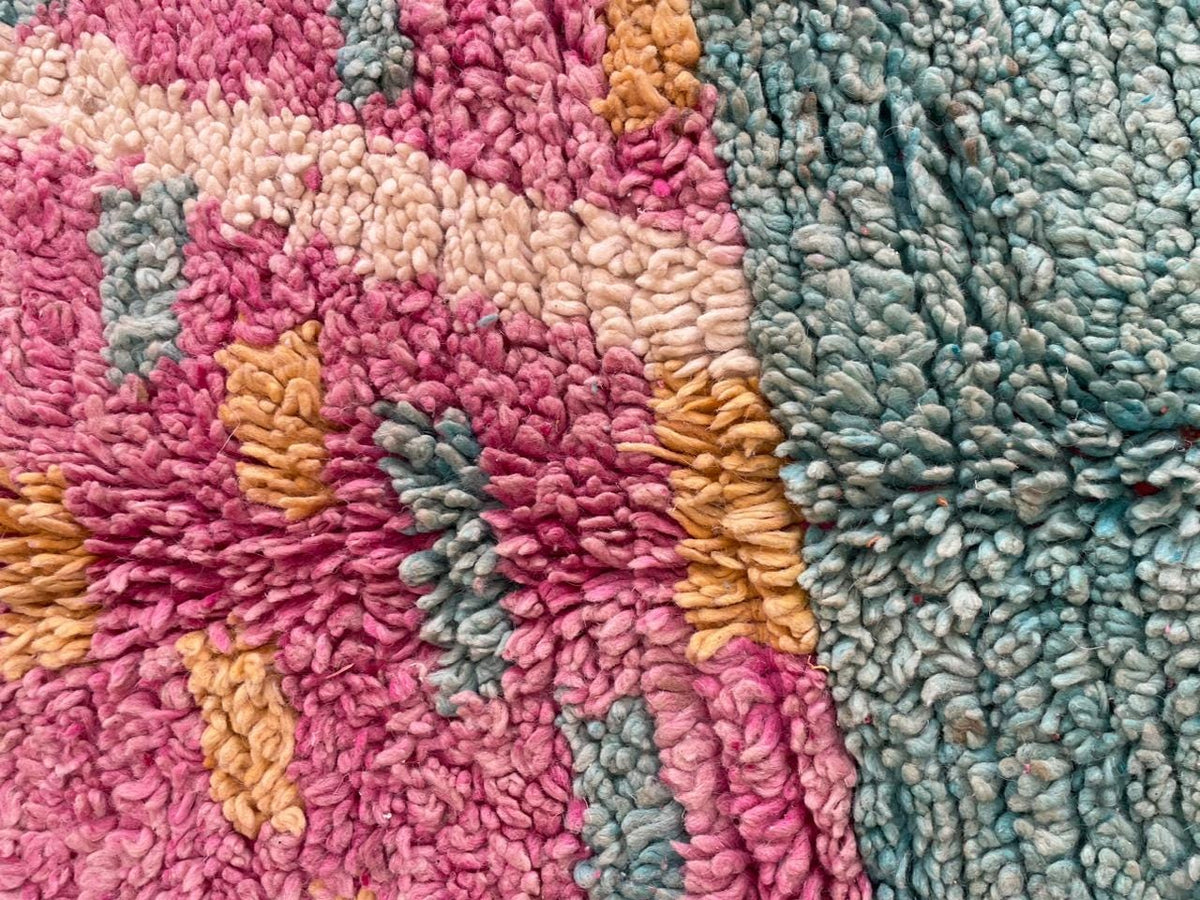 Detail close-up of the pink Moroccan rug showcasing intricate patterns and a woven texture.