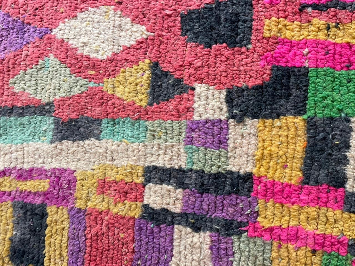 Detail close-up of the textured fabric and colorful patterns on the rug.