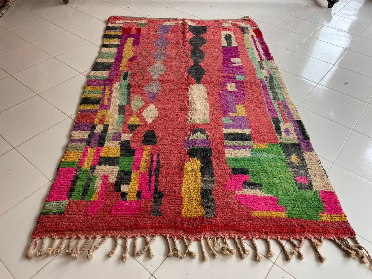 Front view of a red vintage Moroccan rug showcasing colorful tribal patterns.