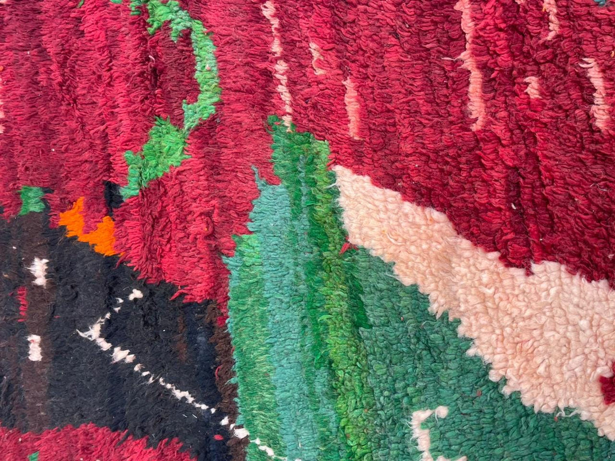 Detail close-up of the red vintage Moroccan rug displaying tribal patterns and rich colors.