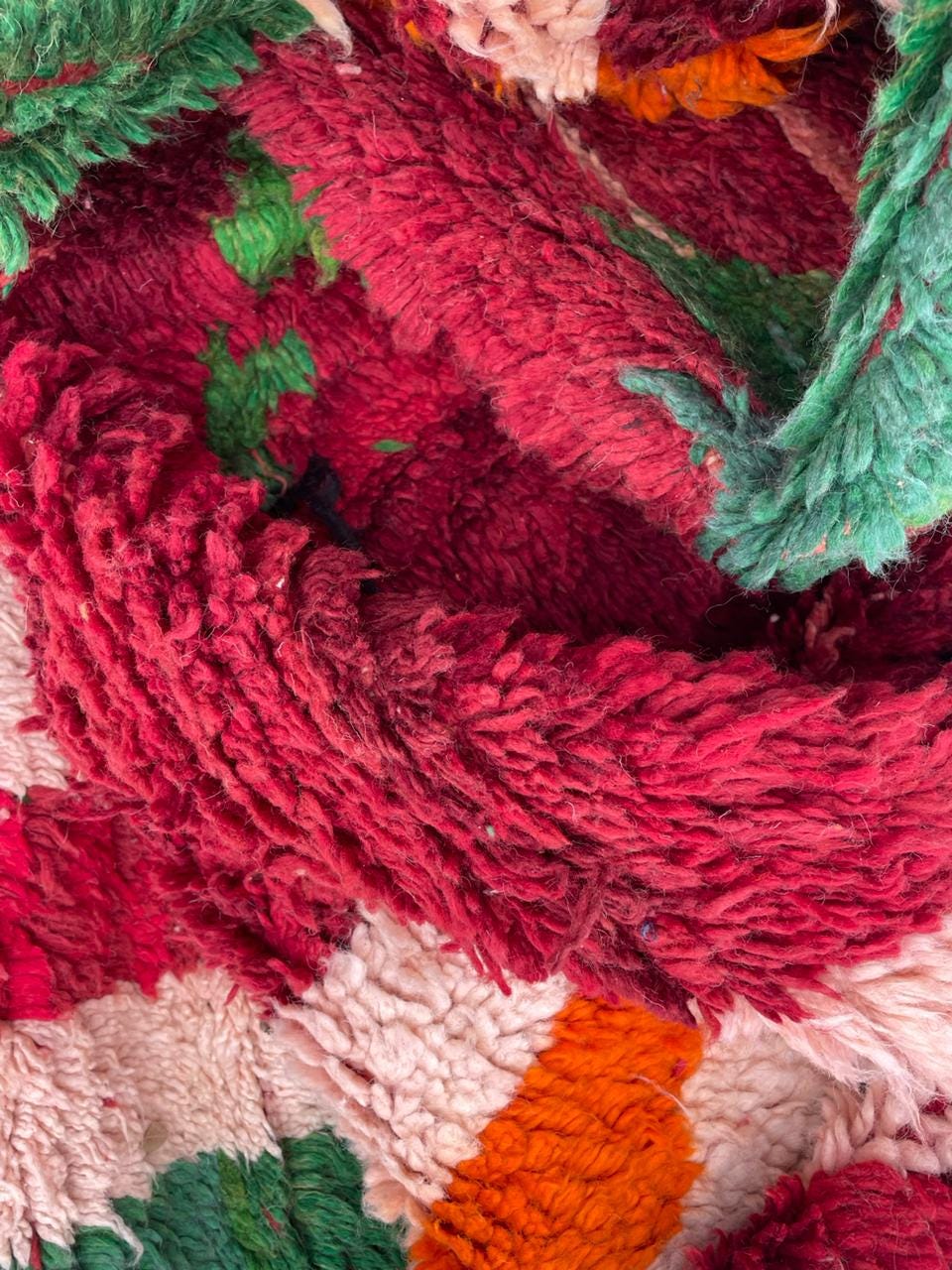 Detail close-up of the red vintage Moroccan rug featuring textured surface and tribal designs.