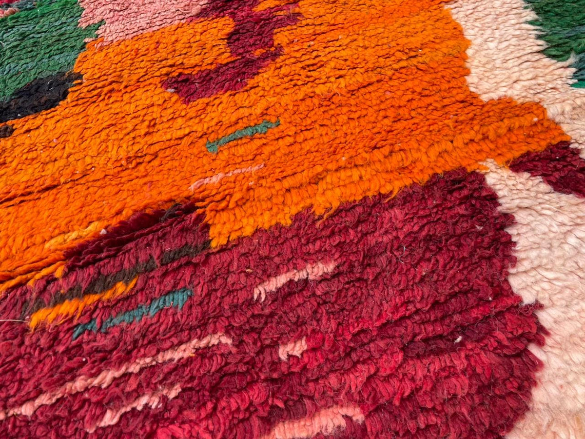 Detail close-up of the red vintage Moroccan rug with tribal patterns and rich colors.