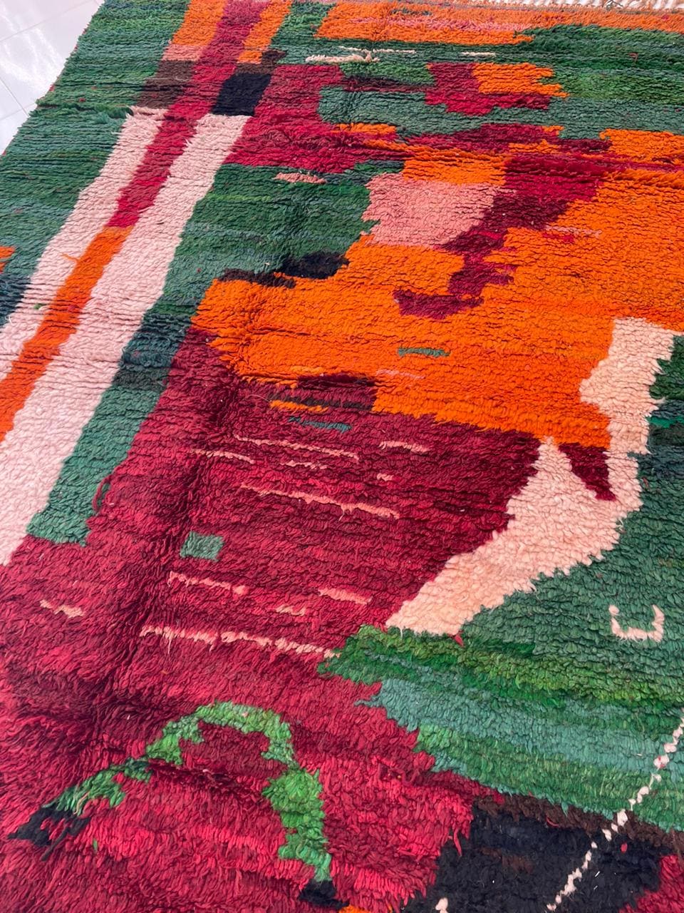 Detail close-up of the red vintage Moroccan rug highlighting its tribal designs and colors.
