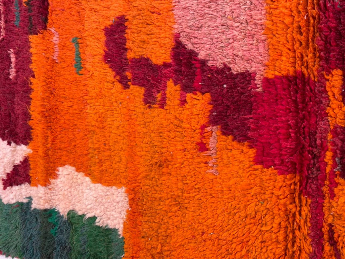 Detail close-up of the red vintage Moroccan rug with tribal designs and vibrant colors.
