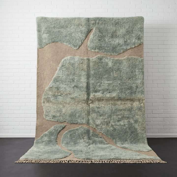 Front view of the sage green Moroccan rug featuring an abstract pattern on a studio background.