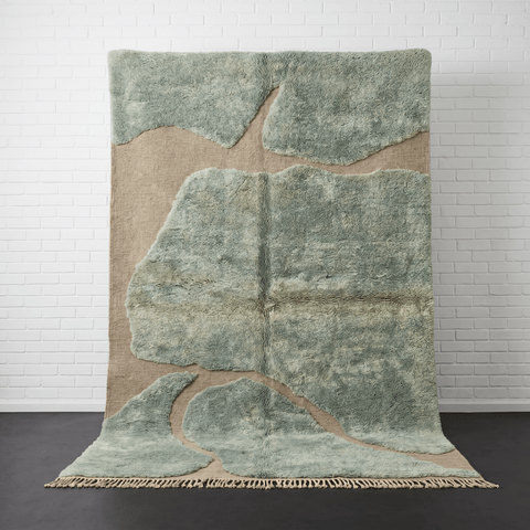 Front view of the sage green Moroccan rug featuring an abstract pattern on a studio background.