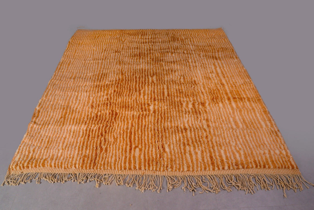 Top view of an orange and beige Moroccan Mrirt rug featuring soft texture and fringed edges.