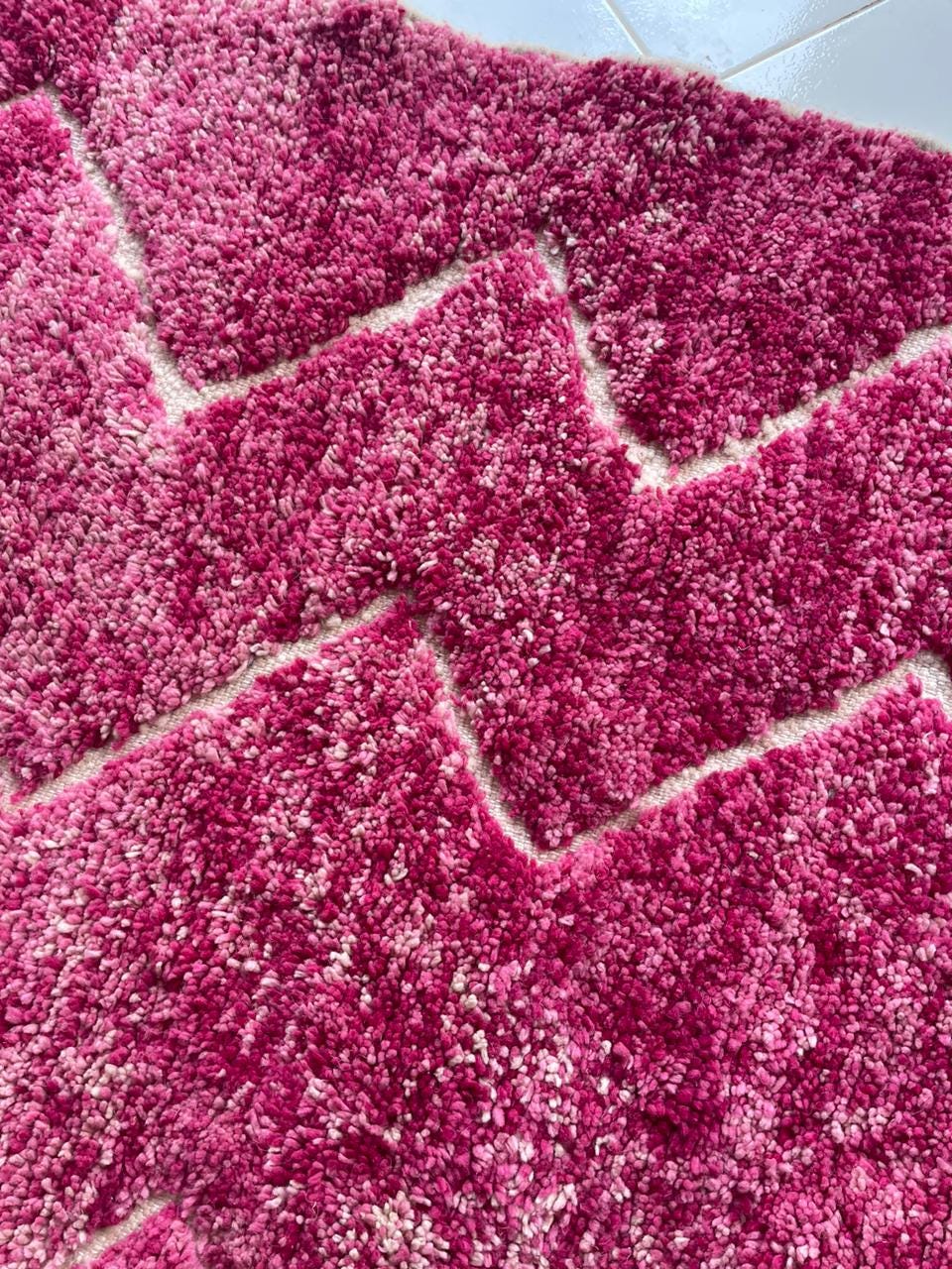 Close-up detail of a pink Moroccan rug featuring a textured pattern.