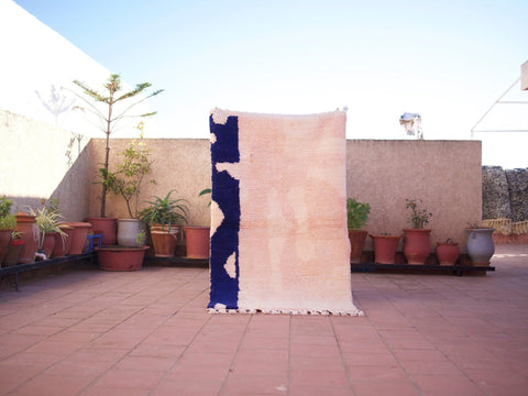 Lifestyle shot of a pink Moroccan rug in an outdoor setting, showcasing boho style.