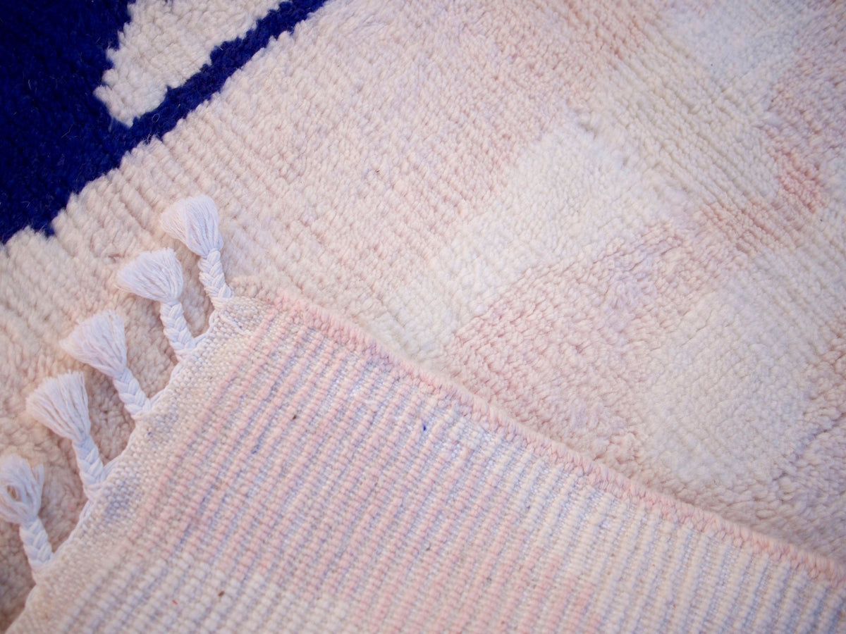 Close-up detail of the woven pattern on the pink Moroccan rug.