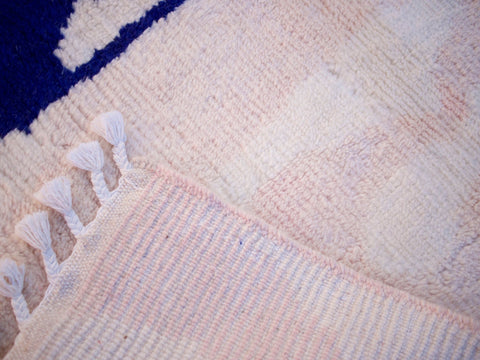 Close-up detail of the woven pattern on the pink Moroccan rug.