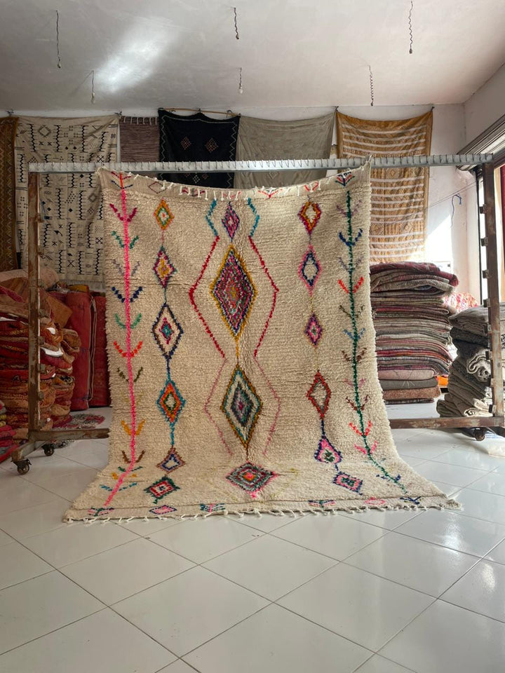 Lifestyle shot of a colorful vintage Moroccan rug with geometric patterns in a natural setting.