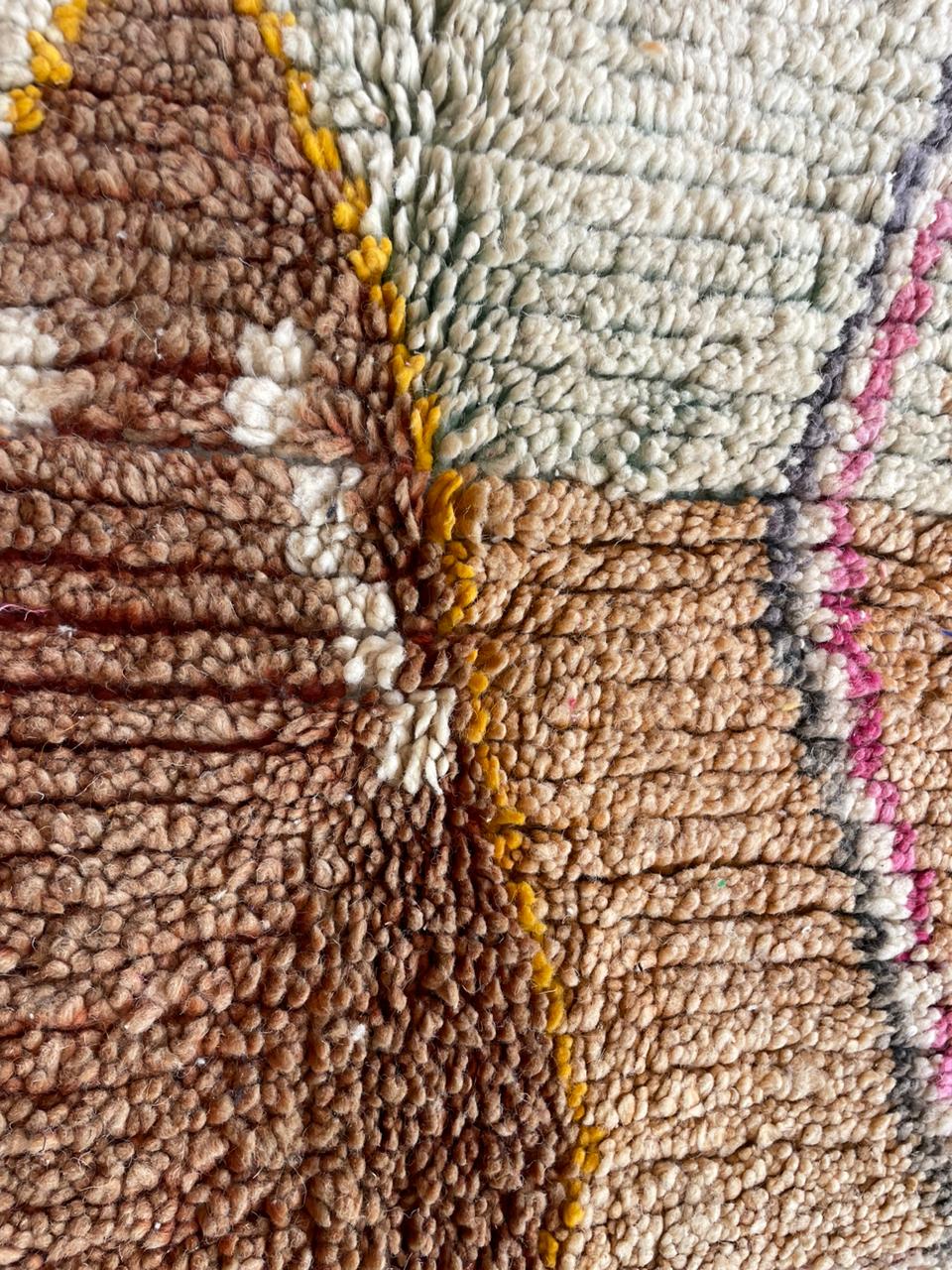 Detail shot of a woven textile with abstract patterns in brown, white, and pink.