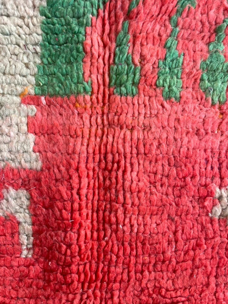 Close-up detail of a colorful textile pattern on a vintage Moroccan rug.