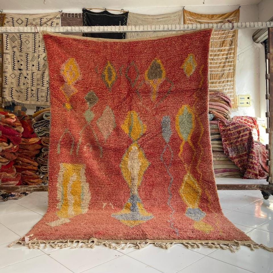 Lifestyle shot of a large decorative red vintage Moroccan rug featuring a geometric design.