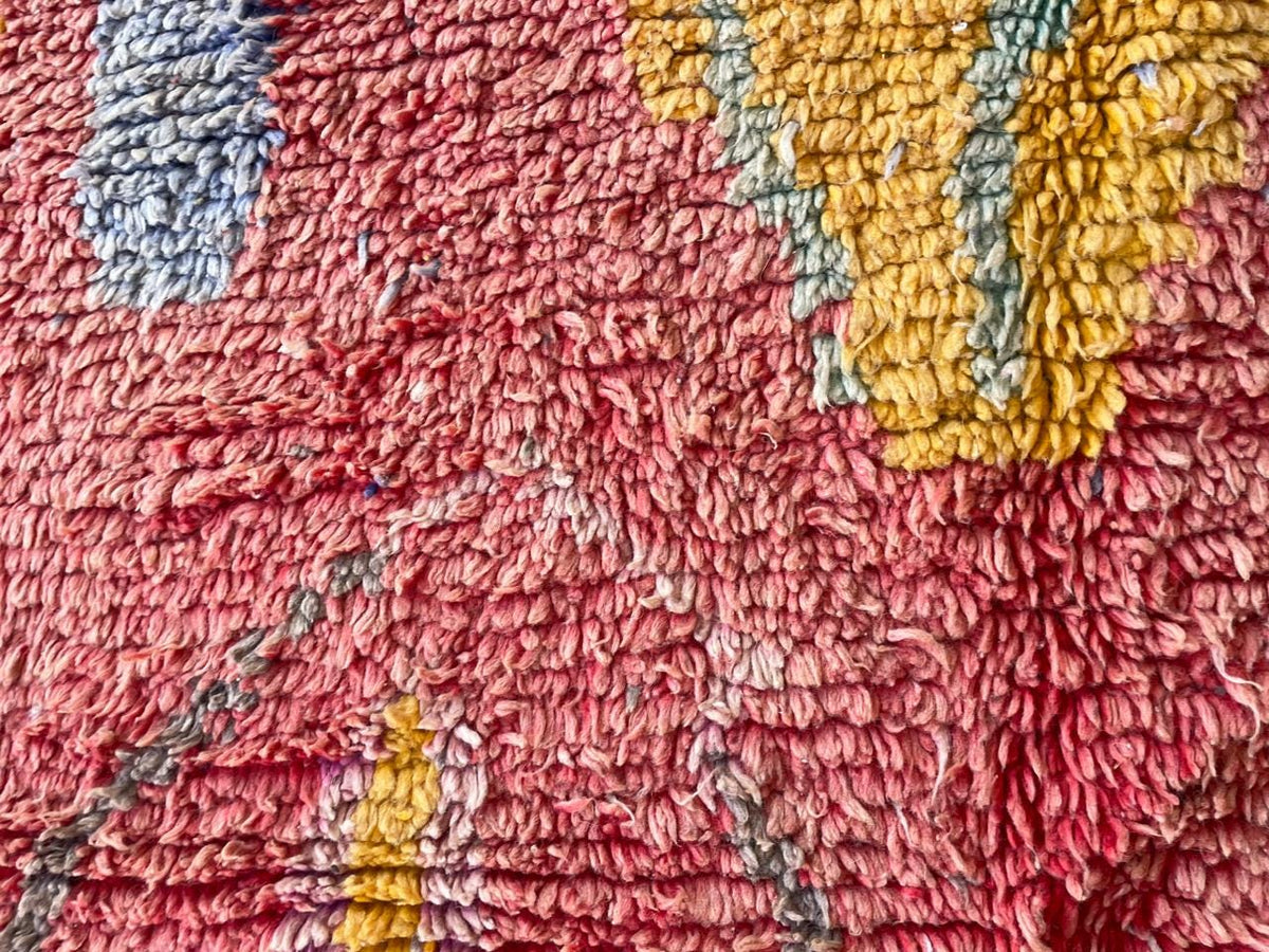 Top view of a red vintage Moroccan rug highlighting its abstract design and colorful patterns.
