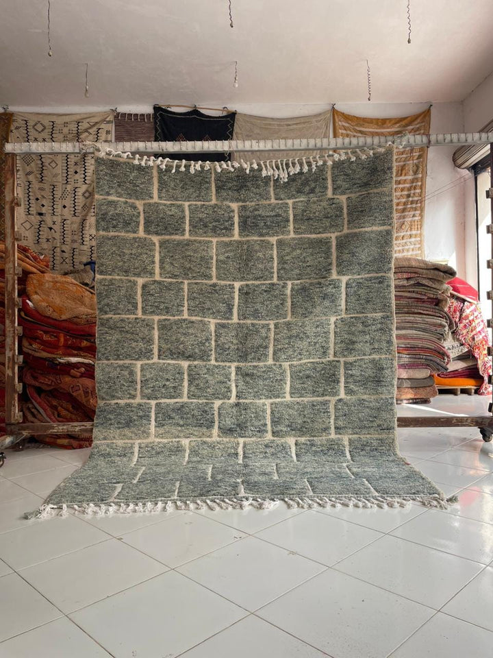 Lifestyle shot of a vintage Moroccan rug with a geometric pattern in cream and black.
