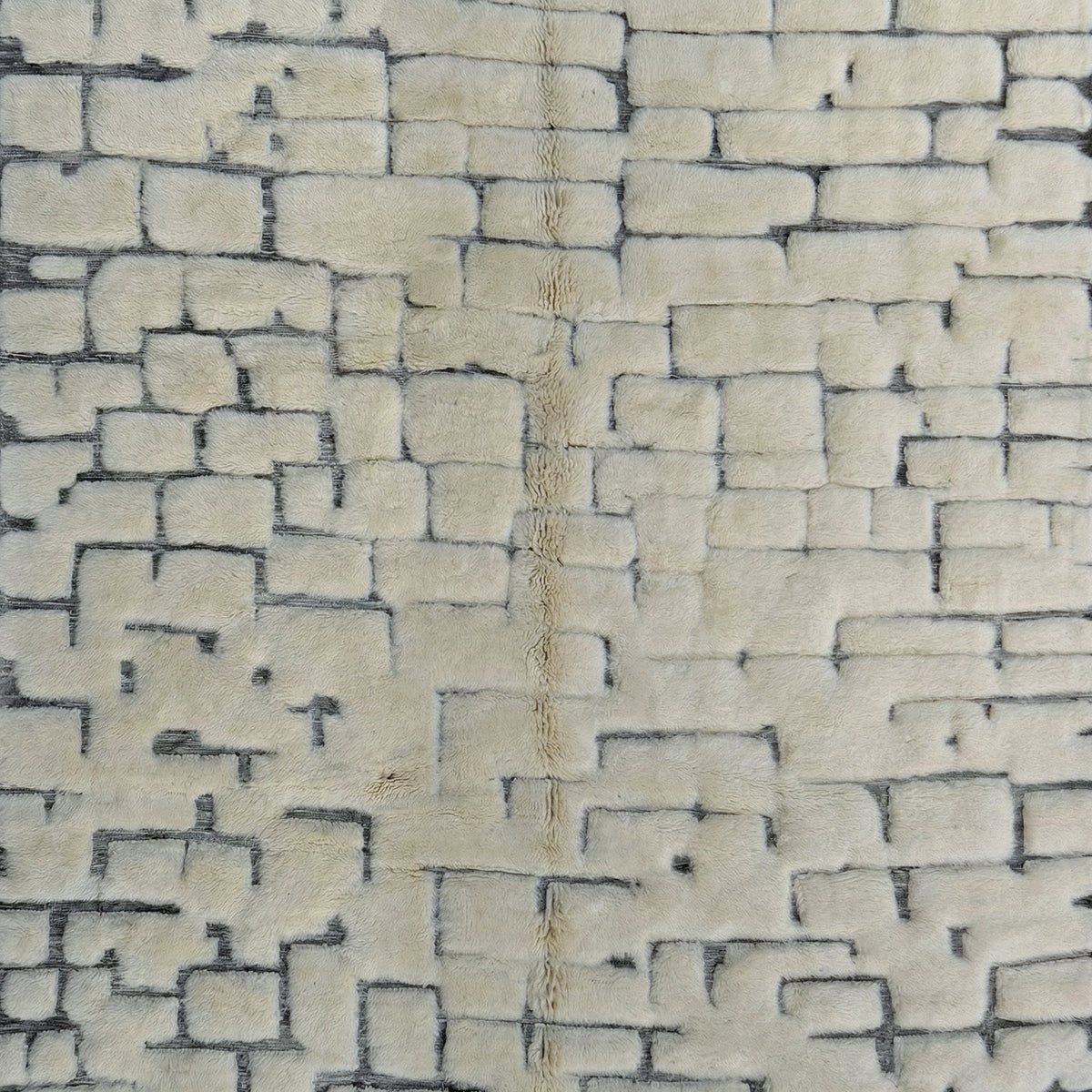 Lifestyle shot of the cream Moroccan rug featuring tufted texture and brick pattern in a natural setting.