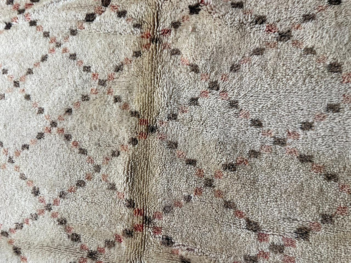 Close-up detail of a diamond patterned Moroccan rug in white, black, and red.