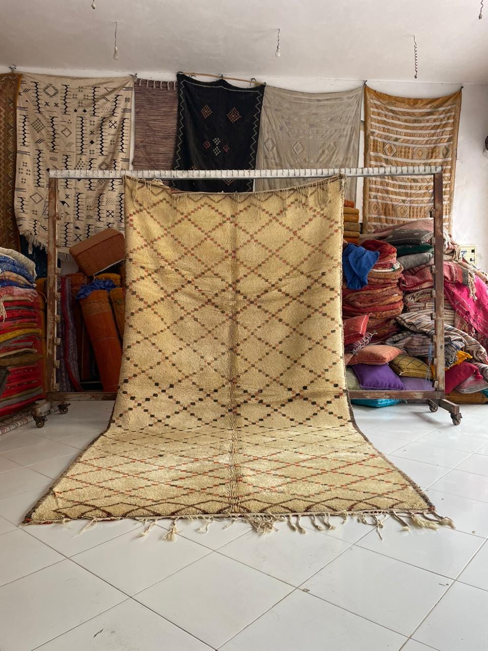 Lifestyle shot of a beige and brown geometric Moroccan rug with fringe edges.