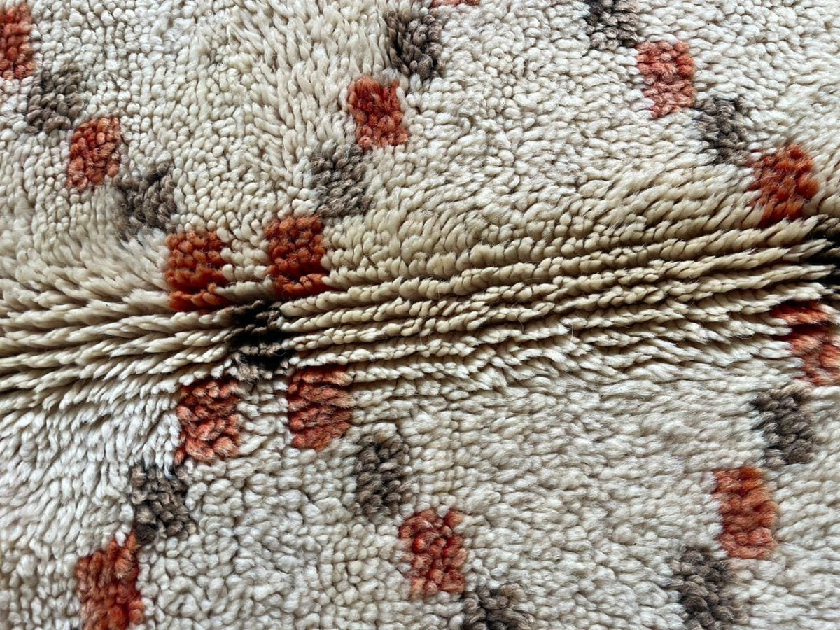 Close-up detail of a diamond patterned Moroccan rug in white, black, and red.