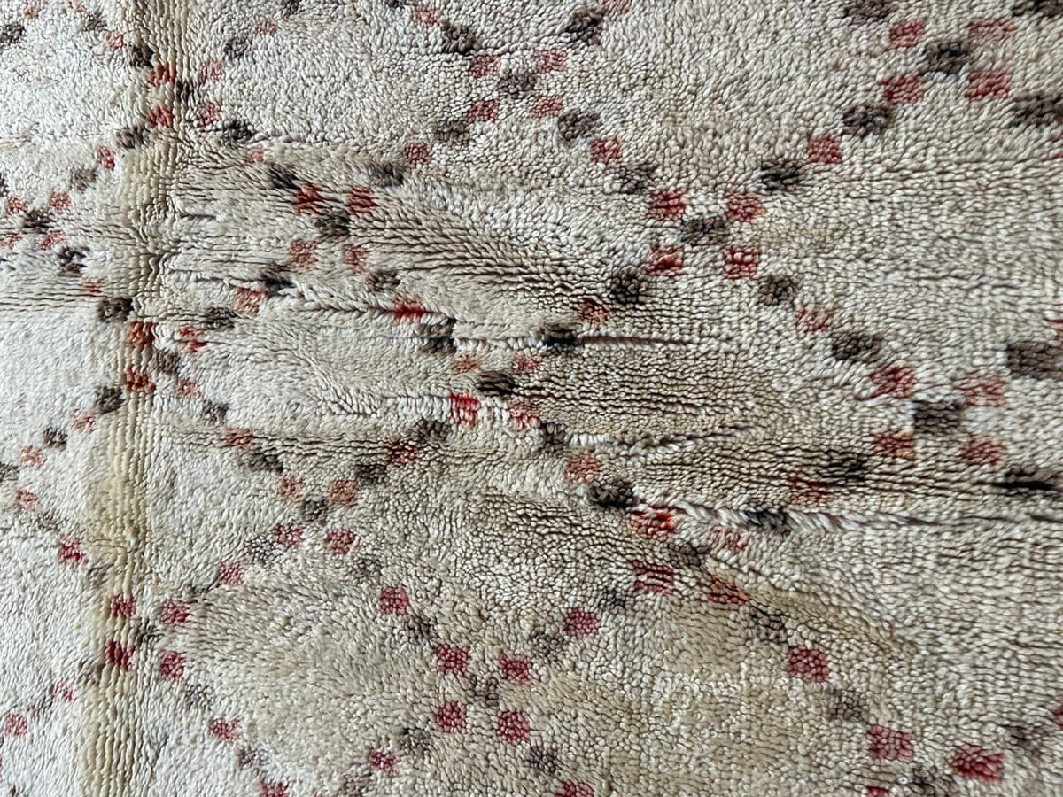 Close-up detail of a diamond patterned Moroccan rug in white, black, and red.