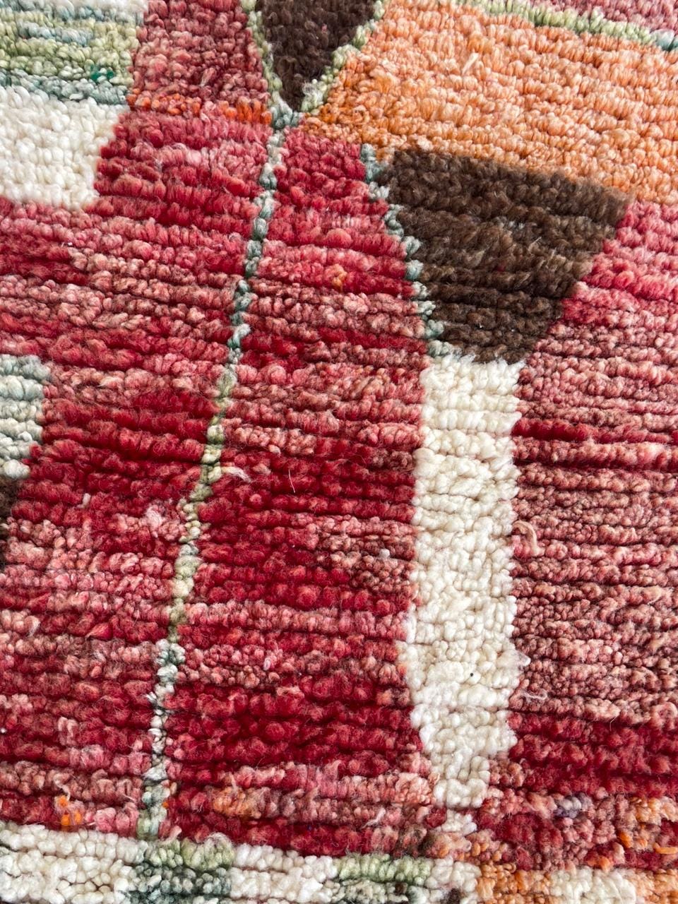 Detail shot of a vintage rug showcasing a textured weave with colorful accents.