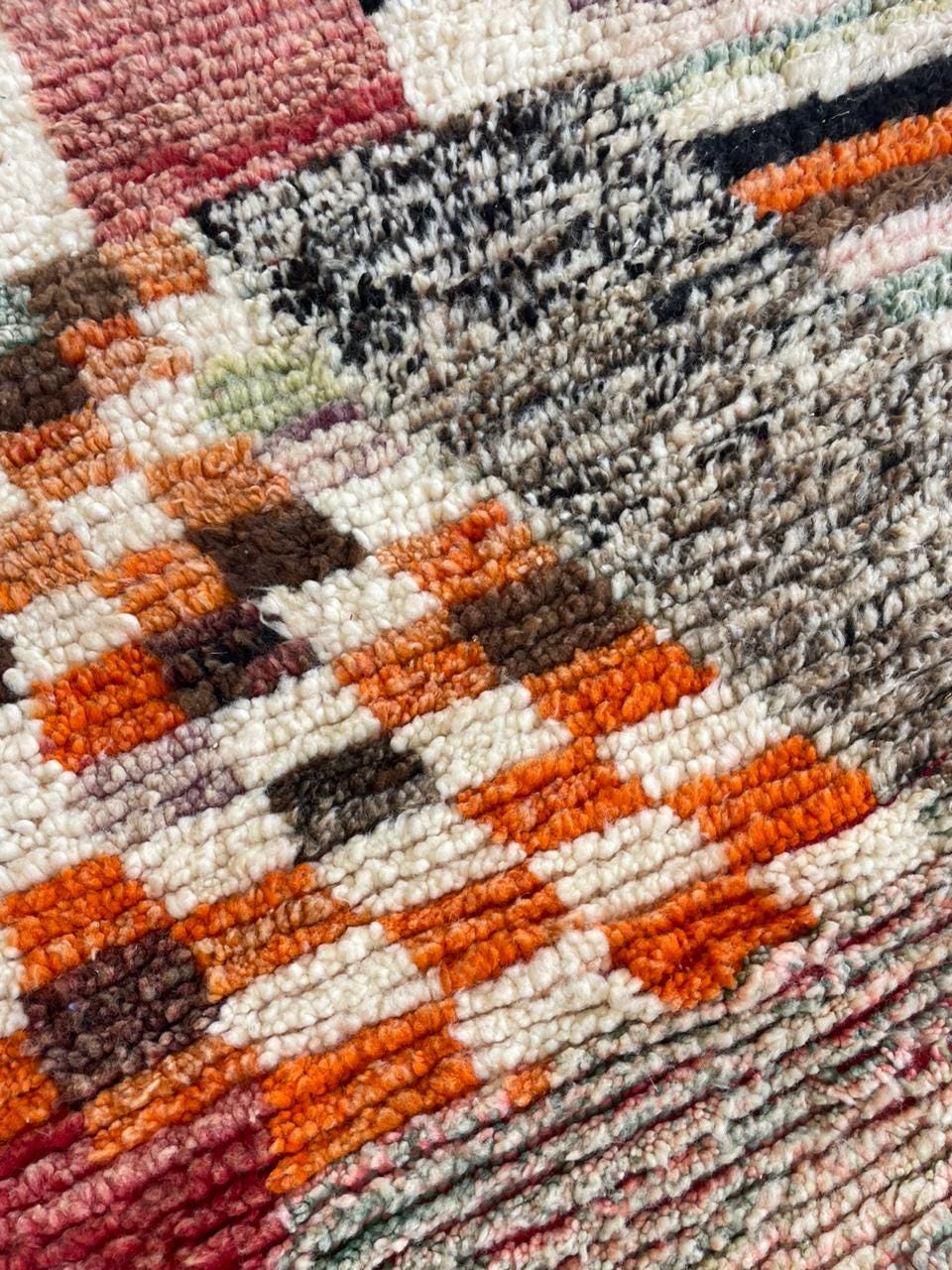 Top view of a vintage Moroccan rug highlighting its intricate geometric patterns and colors.