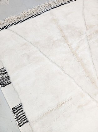 Close-up detail of a corner of a white and black tufted rug highlighting geometric pattern and texture