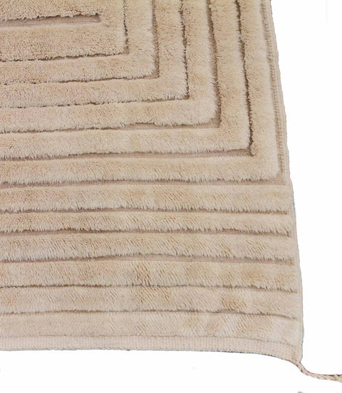 Close-up detail of a white tufted Moroccan rug with a striped design on a white background.