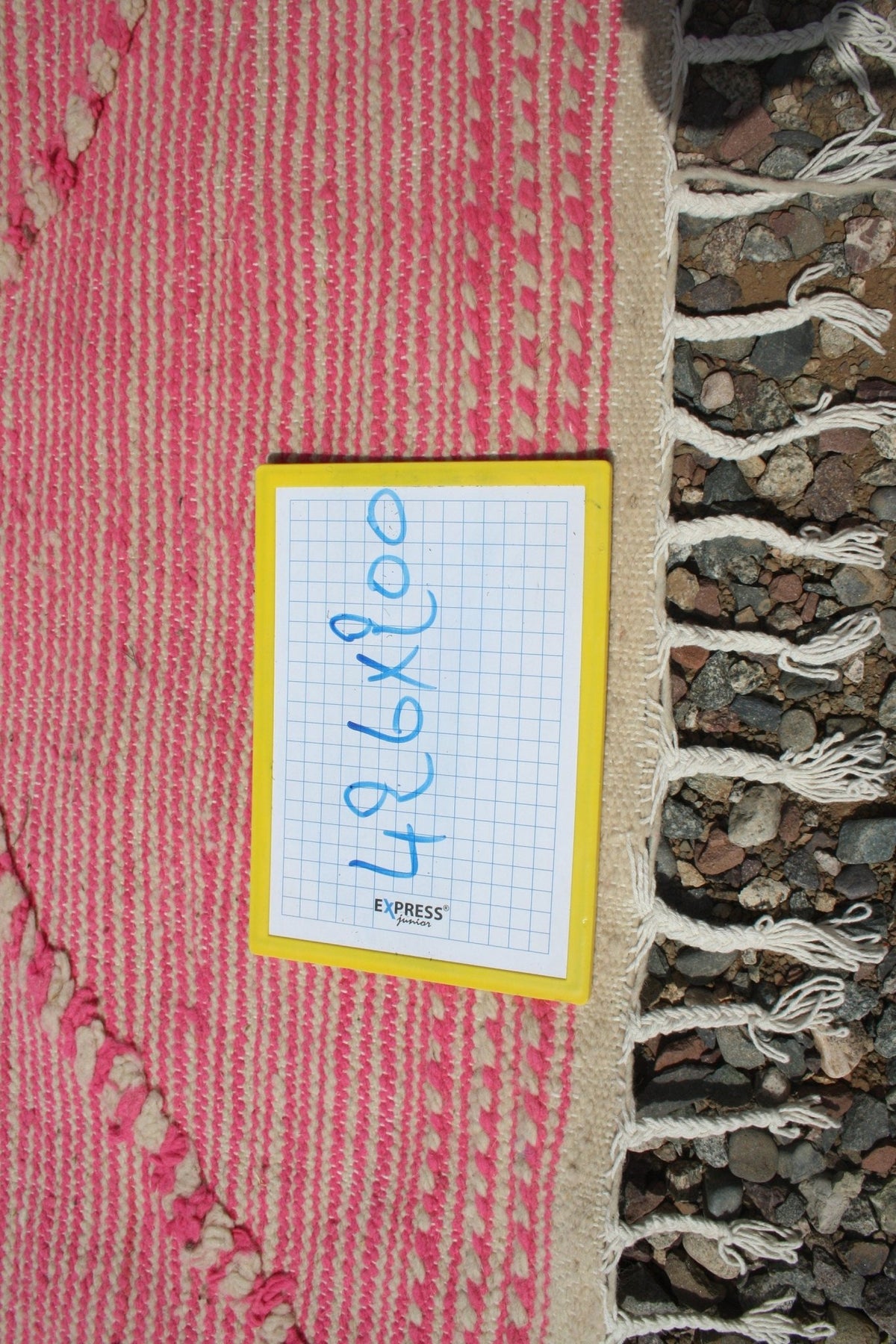 Detail close-up of a pink Moroccan rug showcasing its woven texture and fringe edge.