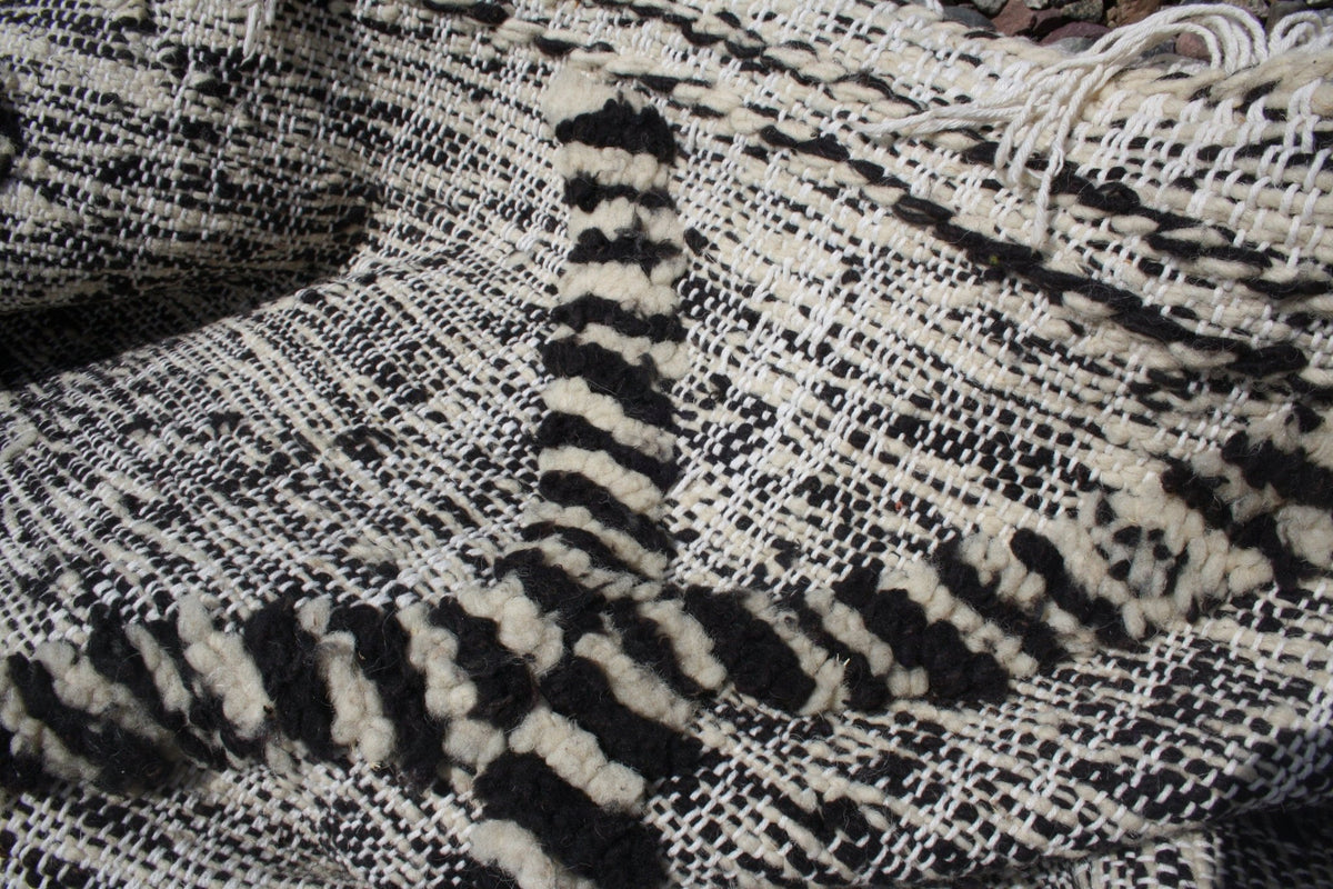 Close-up detail of the black and white rug highlighting geometric patterns.