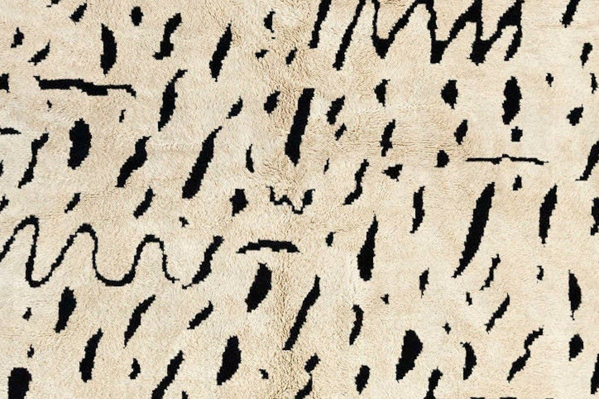 Front view of the taupe speckled Moroccan rug showcasing an abstract pattern in black and off-white.